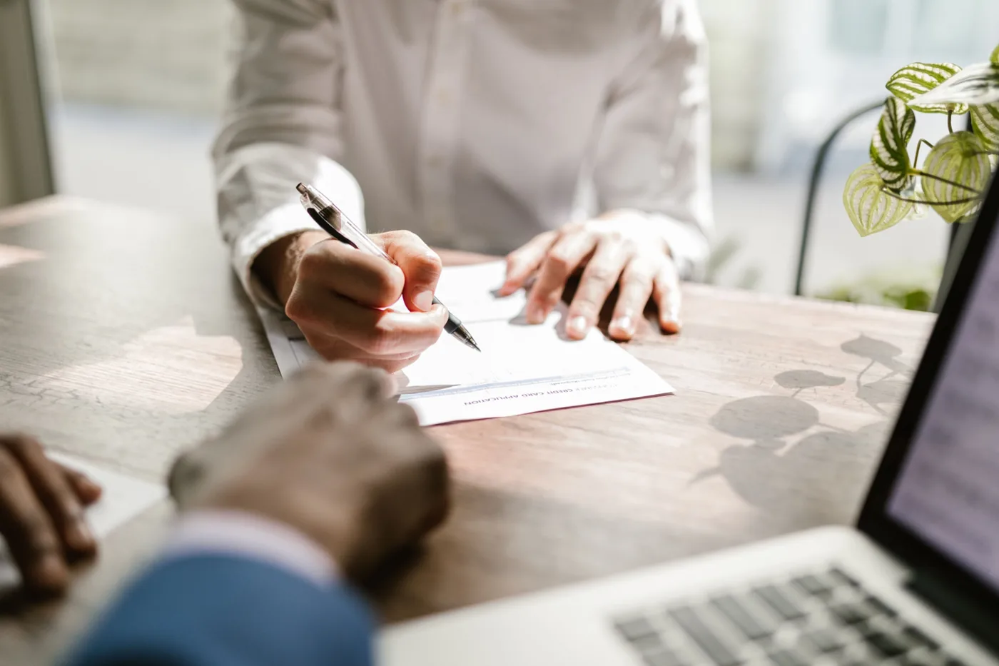 An advisor and client reviewing and signing paperwork at a table